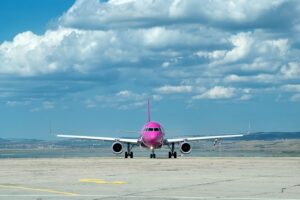 Wizz Air aircraft parked on the airport apron, with the terminal and ground equipment in the background