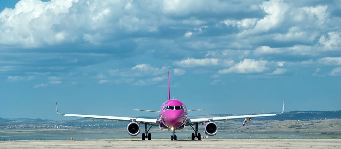 Wizz Air aircraft parked on the airport apron, with the terminal and ground equipment in the background